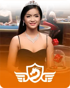 DreamGaming female live dealer in a tiara and black dress, with a dice shaker and casino table in the background