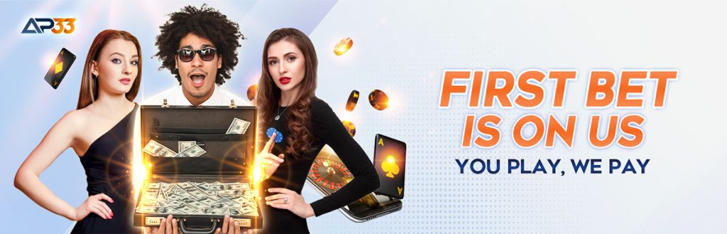 AP33 promotional banner featuring three excited individuals with a glowing briefcase full of cash, casino chips, and cards, promoting the “First Bet Is On Us – You Play, We Pay” offer.